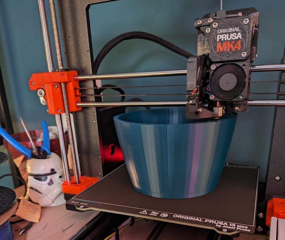 Picture showing a Prusa MK4 printer printing a large object like a planter or vase.